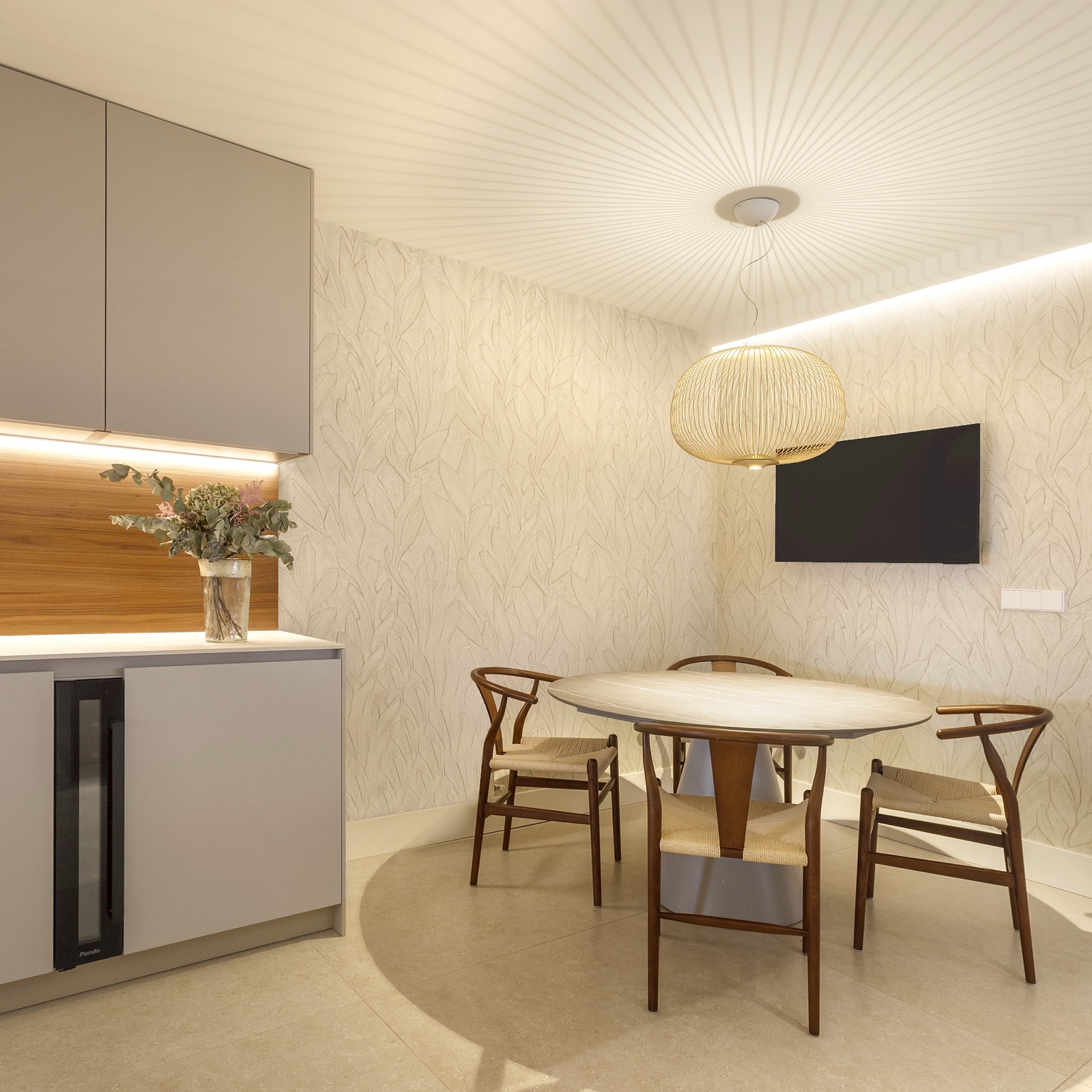 Comedor con papel pintado de hojas, sillas CH24 y lámpara esférica de bambú