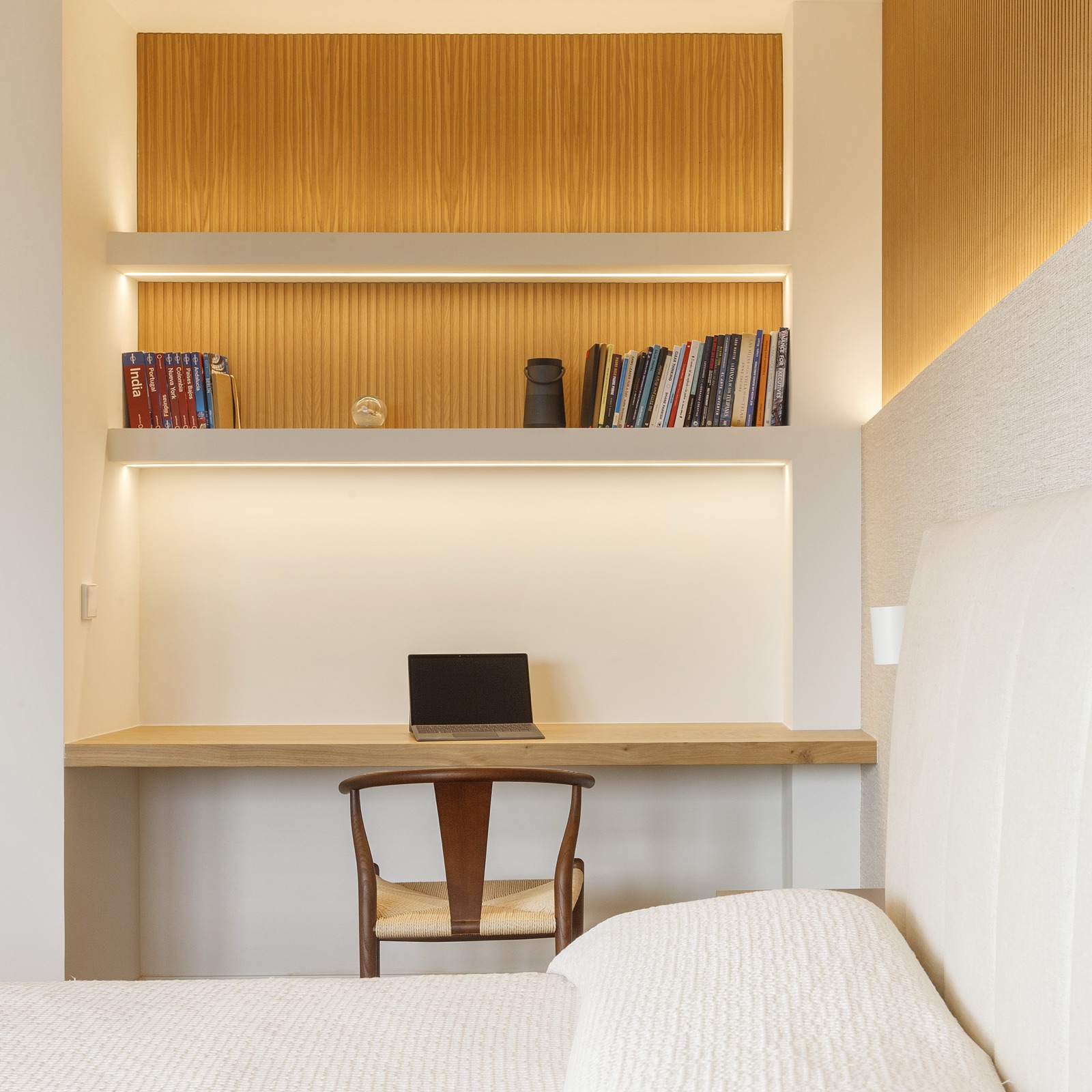 Dormitorio con escritorio integrado en madera de roble y panel ranurado retroiluminado